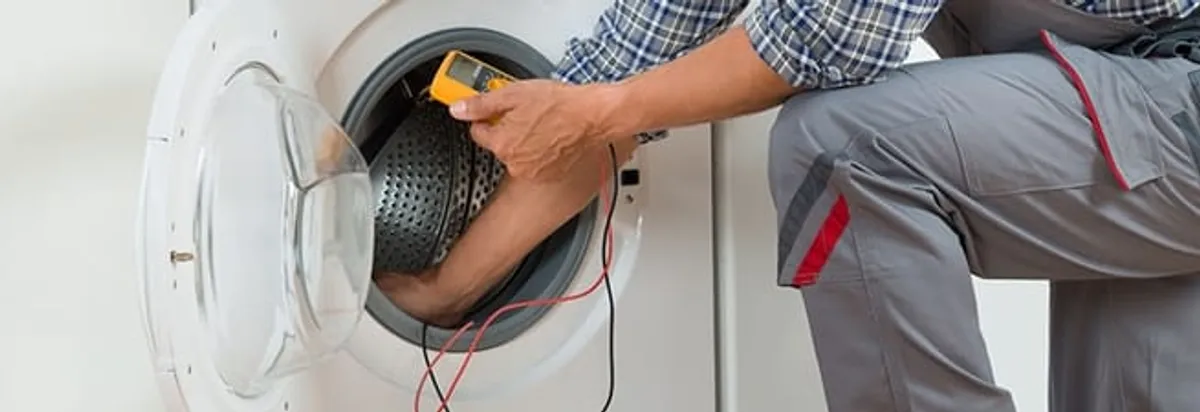 Dryer repair technician inspecting and repairing a clothes dryer in Albuquerque, NM