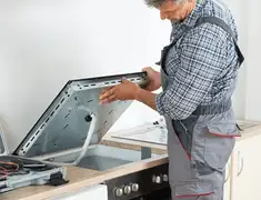 Appliance repair technician installing a built-in cooktop in Albuquerque, NM
