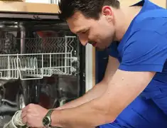 Dishwasher repair technician inspecting and servicing an open dishwasher in Albuquerque, NM