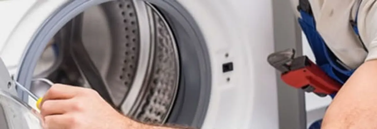 Appliance technician repairing a clothes dryer drum and internal parts in Albuquerque, NM
