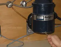Garbage disposal repair technician tightening the mounting ring under a sink in Albuquerque, NM