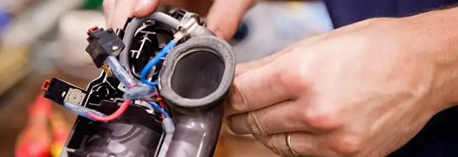Vacuum repair technician reconnecting wiring and components in Albuquerque, NM