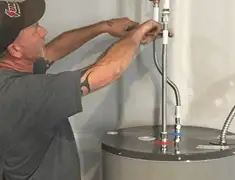 Water heater repair technician tightening supply line connections in Albuquerque, NM